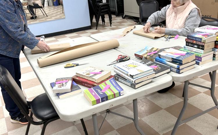 Volunteers wrap books for the Friends of the Library’s Blind Date with a Book display.