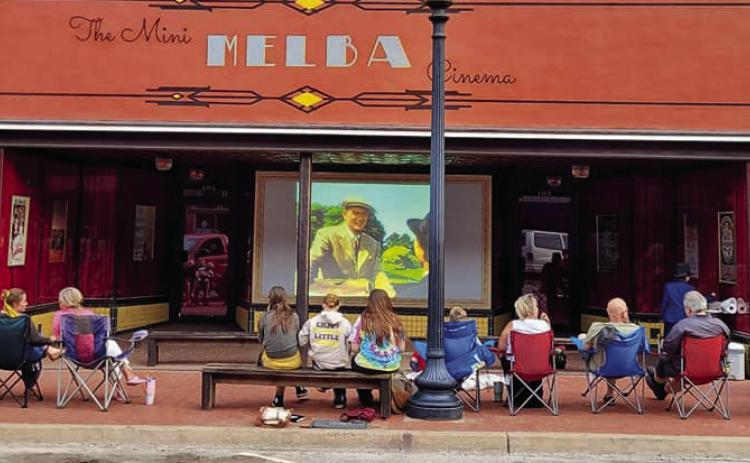 Families watching a free show at the Mini Melba Cinema in Downtown Guthrie.