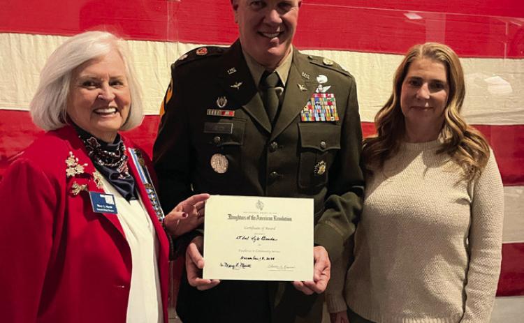 Dr. Mary Merritt, regent of the Samuel King Chapter NSDAR, presents Lt. Col. Kyle Brede with the NSDAR Community Service Award on Dec. 18, 2025. Photo, Nikki Bos