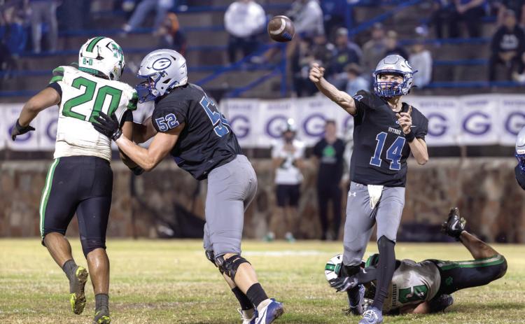 Senior Guthrie quarterback Daelon Rice releases a pass under pressure during last Friday’s playoff game against Bishop McGuinness at Jelsma Stadium. Photo by Brent Fuchs.