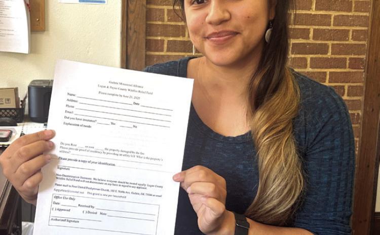 Pictured is Shu Fields, Office Administrator at the Guthrie First United Presbyterian Church, holding an application form for the Relief Grant.