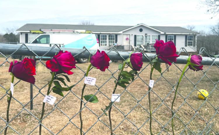 Red roses are placed on a fence near the scene of an apparent murder-suicide in Logan County in tribute. Photo by Bobbi Waddell.