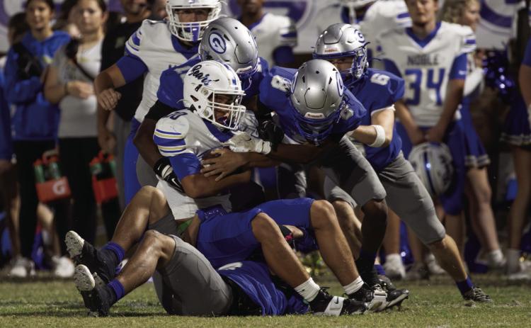 Guthrie defenders, including Demetrious Thomas (8) and Collin Walters (6), tackle a Noble ball carrier during the first half of Guthrie’s 28-21 win on Friday, Oct. 23, 2026, at Jelsma Stadium in Guthrie. Photo by Brent Fuchs.