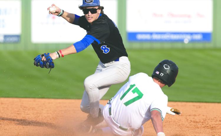 Guthrie’s Lance Evans (8) throws to first base after fielding the ball Friday, March 13, 2026, at Bishop McGuinness High School. Guthrie defeated Bishop McGuinness 8-5.