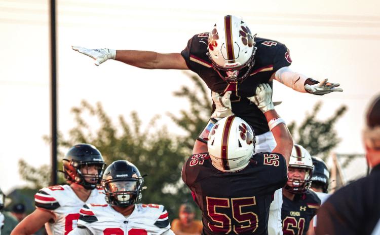 A Cashion player is lifted by a teammate in celebration during the Wildcats' 37-14 Week 1 win over Crescent on Friday, Aug. 28, in Cashion. Photo by Reece Heck.
