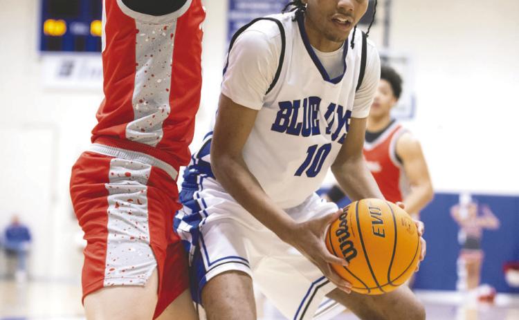 Guthrie’s Jahvari Harper looks to score against a Carl Albert defender during the Blue Jays’ 88-69 loss Feb. 6.