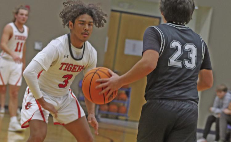 Crescent_s CJ Wilson plays defense against Oilton’s Zane Corter in their game at Coyle Invitational.