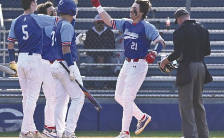 Guthrie’s Owen Wilder celebrates with his teammates at home plate on March 3. Photo by Brett Tennyson