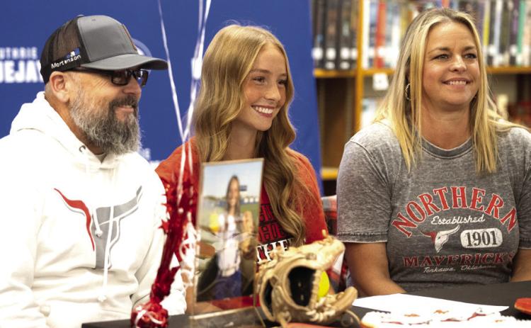 Codi with her parents at her signing. Photo by Brent Fuchs