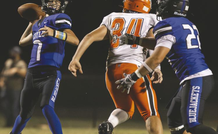 Coyle quarterback Ticen Hock throws a pass as James Lackey, right, blocks Yale’s Cody Whitington during the Bluejackets’ homecoming game. Coyle won 30-8. Photo by Brent Fuchs