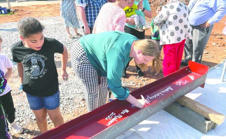 Attendees sign a structural beam during the beam signing ceremony at Coyle Public Schools, leaving their mark on the district’s new Agricultural Education and STEM facility. Photo courtesy Renaissance Architecture.